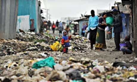 MDG : Poor and poverty : Nairobi's Mukuru -kwa-Njenga slum residents stand among rubbish, Kenya