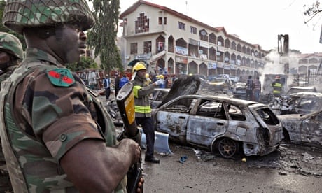 A soldier stands guard at the scene of an explosion in Abuja