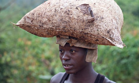 MDG : Smuggling cocao from Ghana to Ivory Coat : A young boy carries a bag of cocoa on his head 