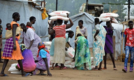 MDG : Food in Africa : Women carry maize flour sacks during a food distribution, Juba, South Sudan