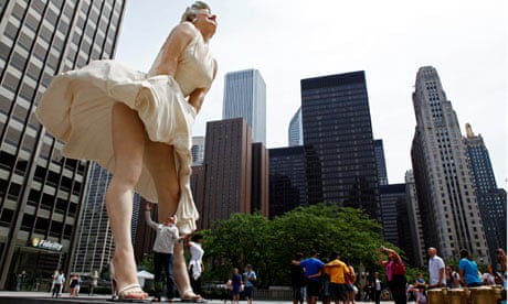 A man jokingly looks under the dress of a 26-foot tall statue of Marilyn Monroe in Chicago