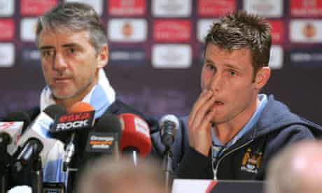 Roberto Mancini, manager of Manchester City, and James Milner face the media in Poznan