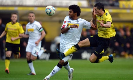 Borussia Moenchengladbach's Dante is challenged by Robert Lewandowski of Dortmund
