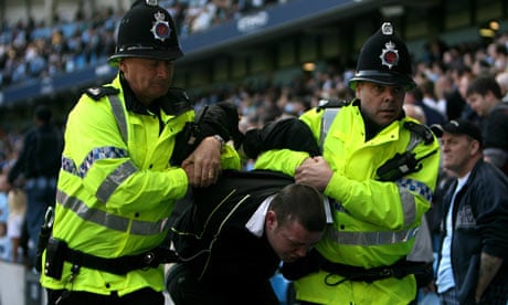 A fan is evicted from Eastlands during a derby encounter