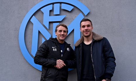 The Internazionale head coach Roberto Mancini, left, shakes hands with Lukas Podolski