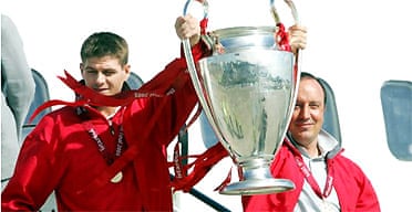 The Liverpool captain, Steven Gerrard (left), and manager, Rafa Benitez, step from the plane at Liverpool John Lennon airport with the Champions League trophy 