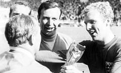 Bobby Moore passes the World Cup trophy to manager Alf Ramsey