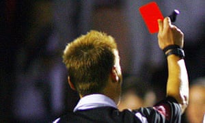 A referee brandishes a red card