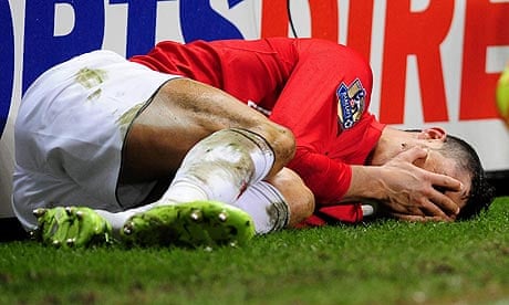 Cristiano Ronaldo holds his face after a tackle on him by Steven Taylor