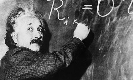 Albert Einstein writes a complicated equation on a blackboard