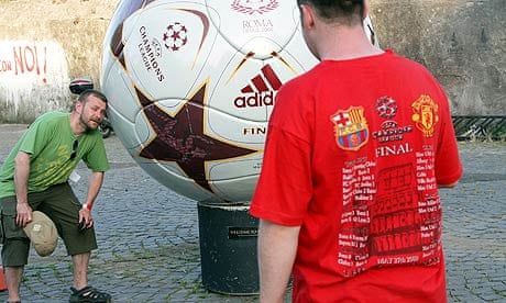Manchester United fans pose in front of a giant football at Ponte Milvio