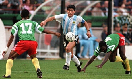 Argentina's Diego Maradona juggles with the ball as he runs past Cameroon's Benjamin Massing