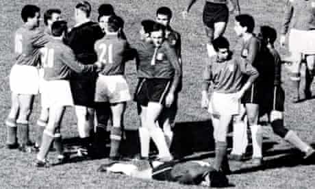 Aston tries to bring order after fighting breaks out. Chile’s Sánchez, 11, lies injured after an Italy foul.