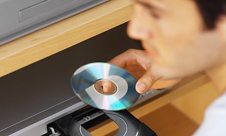 man puts DVD disc in machine
