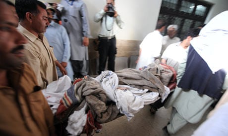 Relatives carry the body of a suicide blast victim at a hospital in Chakwal, Pakistan