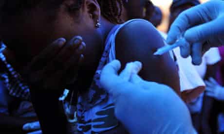 A girl receives a vaccine at the National Stadium of Port-au-Prince