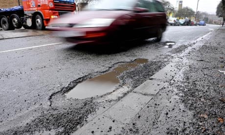 A car passes a pothole on a road in Bristol, January 2010