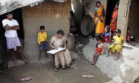 Indian census worker Rumnima Das takes information on Mahesh Shah (l), and his family