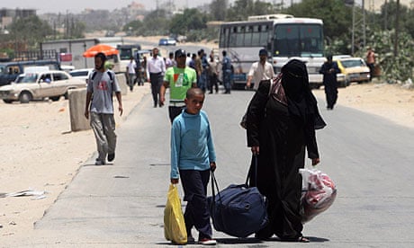Palestinians carry their luggage to the Rafah border crossing between Egypt and Gaza.