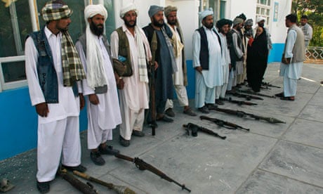 Afghanistani Taliban fighters surrender their weapons to authorities in Herat