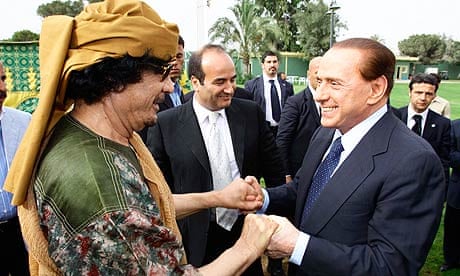 Libyan leader Muammar Gaddafi welcomes the Italian prime minsiter, Silvio Berlusconi, to Tripoli