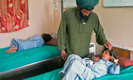An Afghan man talks to his wounded child at a hospital in southern Kandahar city.