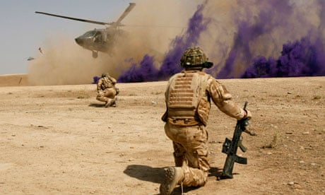 British soldiers cover themselves from dust as a helicopter lands at Malgeer in Helmand province.