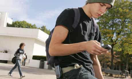 An American student checks in on his smart phone, above.