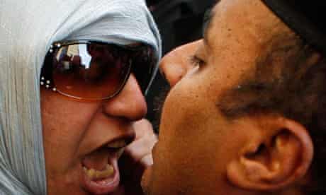 An anti-government protester clashes with a policeman in Cairo.