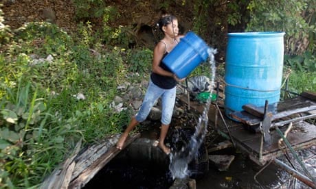 A woman collects water from a public well in San Cayetano, west Nicuragua