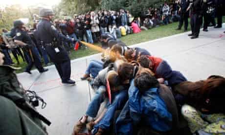 A police officer uses pepper spray at an occupy protest at University of California