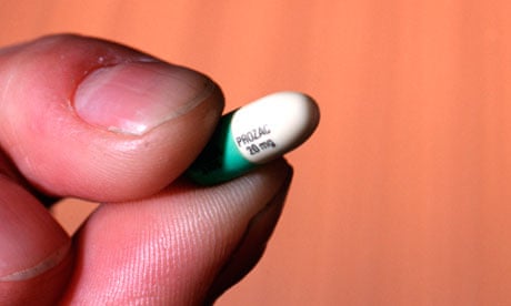 Prozac pill held between finger and thumb