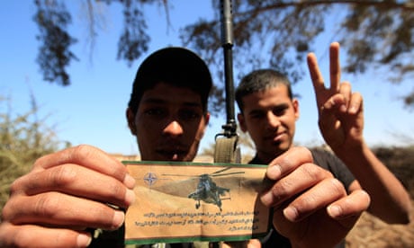 A Libyan rebel holds a flyer Nato aircraft dropped outside Misrata