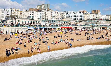People enjoy the weather on Brighton beach.