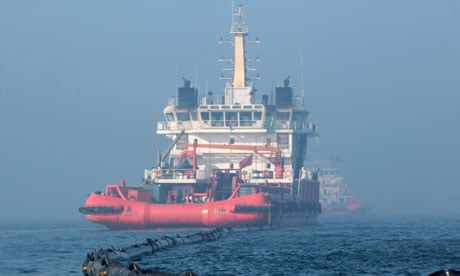 A ship cleans up the leaking oil near the platform C in Bohai Sea, China