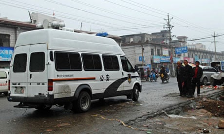 A police van is seen at the site of an axe attack incident in Gongyi