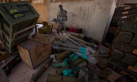 Rebel fighters plunder arms and ammunition from an army base in Ajdabiya, Libya, in March 2011