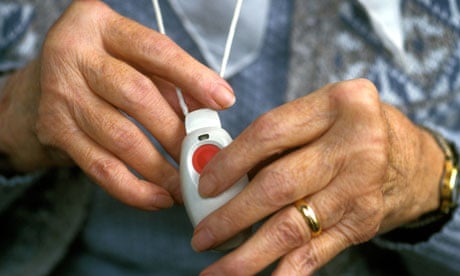 Elderly woman with arthritic hands holding panic alarm UK