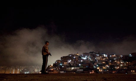 A policeman patrols a slum district of Caracas