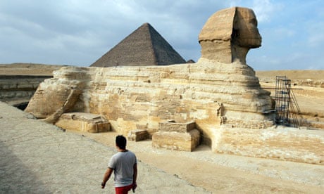 A tourist walks in front of the Great Giza pyramids on the outskirts of Cairo