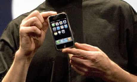 Steve Jobs holding the first iPhone