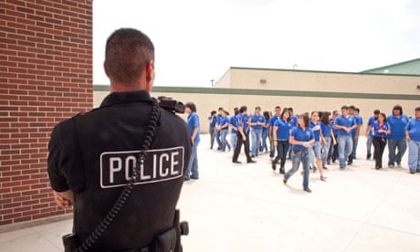 Male police officers supervise and keep an eye on students in South Texas high school