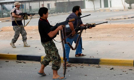 Libyan militiamen shoot at a building in Bani Walid