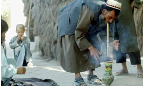 An Afghan farmer smokes hashish