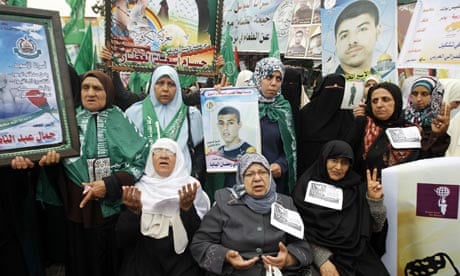 Palestinian women hold pictures of imprisoned relatives at a protest in Gaza City.