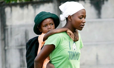 A woman escorts her children home from school in Zimbabwe's capital Harare