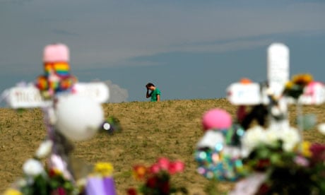 A mourner pauses near the memorial created for the Colorado massacre victims