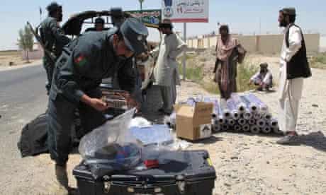 Afghan police inspect vehicles at a checkpoint in Qirshke.