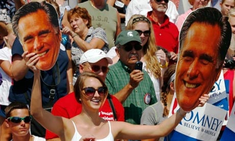 A supporter holds large cutout faces of Mitt Romney at a rally in Michigan earlier this month.