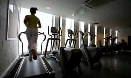 Woman runs on treadmill at gym 
